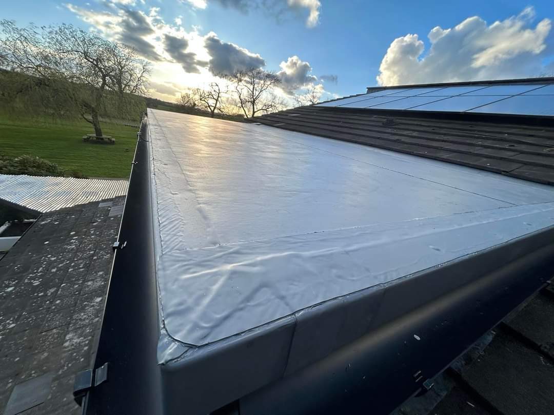 A new flat roof with a neat membrane edge in evening light