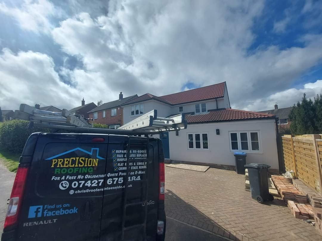 The Precision Roofing van beside a house extension, with the phone number on the door